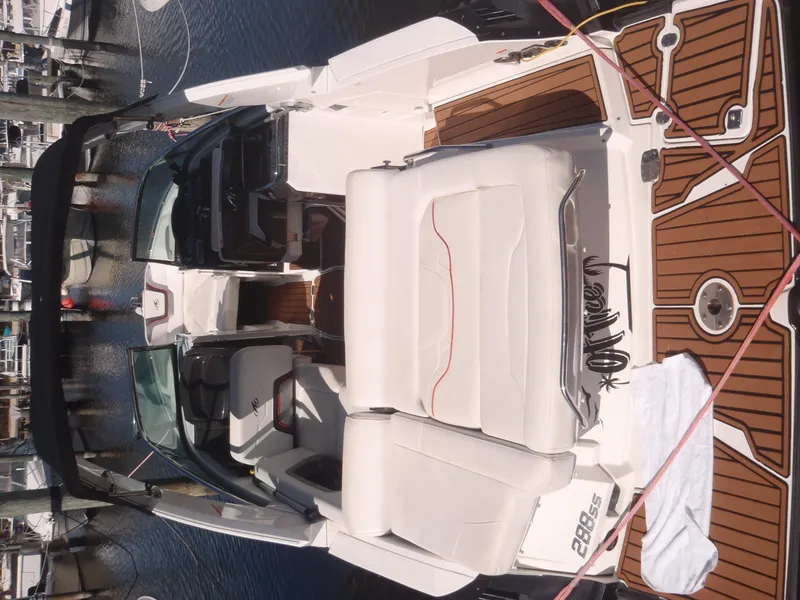 Slide: The Image of 2015 Monterey 288 Super Sport boat with white seating and wood accents docked at marina. - 12