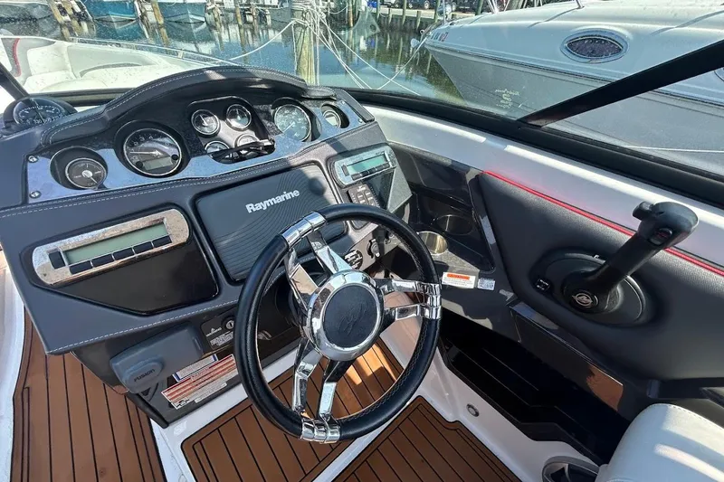 Slide: The Image of 2015 Monterey 288 Super Sport dashboard with Raymarine navigation and sleek steering wheel. - 4