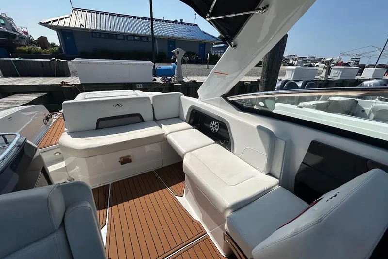 Slide: The Image of 2015 Monterey 288 Super Sport boat interior with white seating and wood flooring. - 5