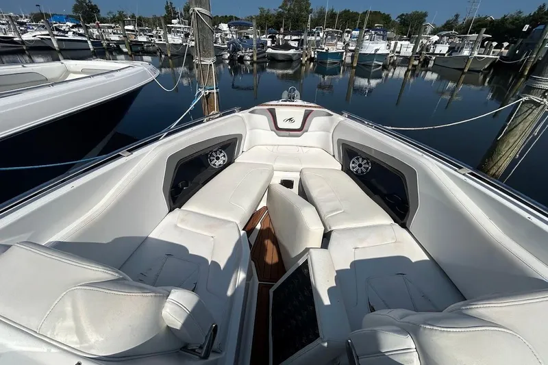 Slide: The Image of 2015 Monterey 288 Super Sport boat interior with white seating at a marina. - 6