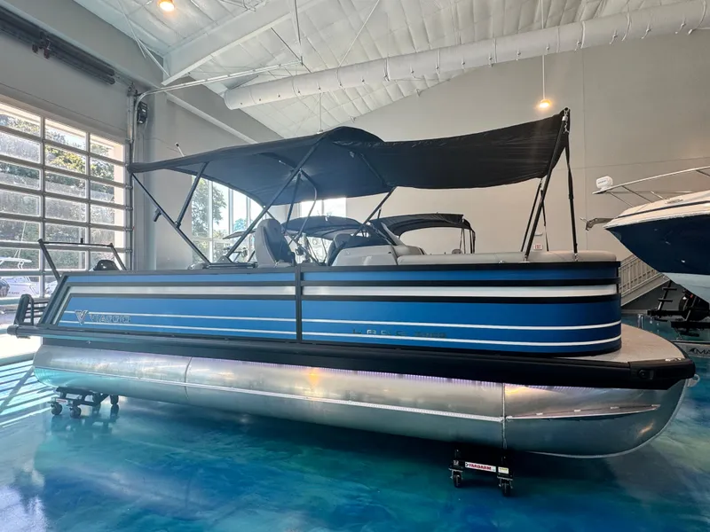 The Image of 2025 Viaggio Lago Z-S pontoon boat in showroom with blue exterior and canopy. - 0