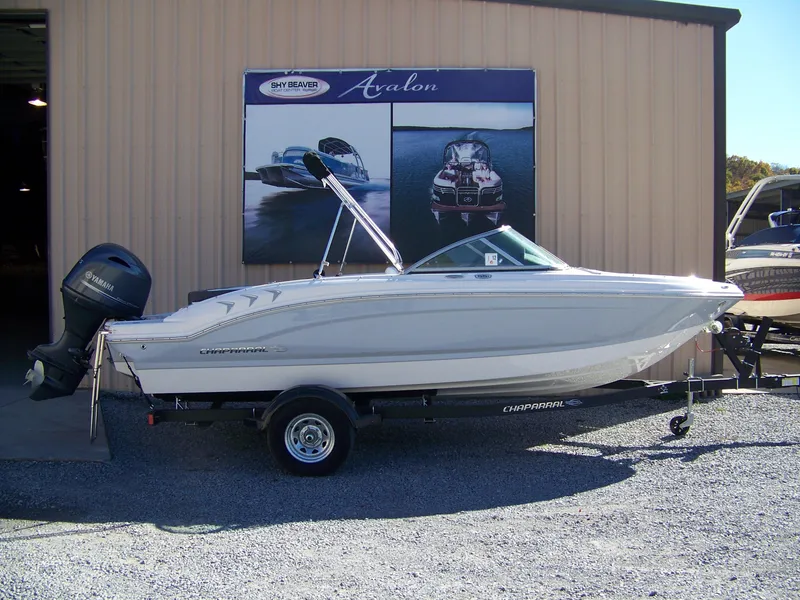 The Image of 2024 Chaparral 19 SSi OB boat displayed outside a showroom. - 1
