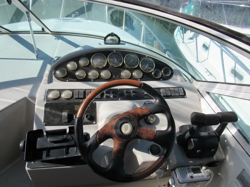 Slide: The Image of 2003 Cruisers Yachts 2870 Express helm with gauges and wood-accented steering wheel. - 11