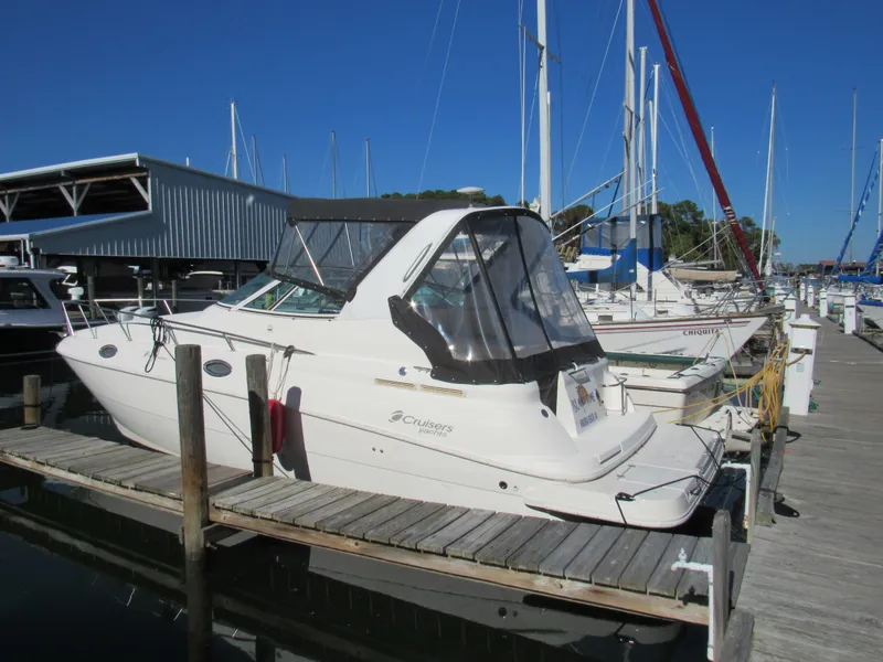 Slide: The Image of 2003 Cruisers Yachts 2870 Express docked at a marina under clear blue skies. - 2