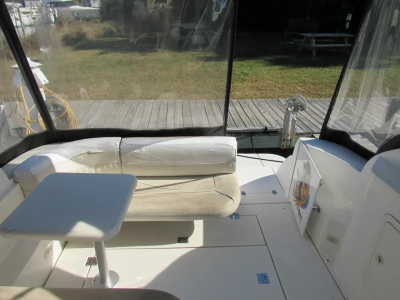 Slide: The Image of 2003 Cruisers Yachts 2870 Express interior with seating and table, docked outdoors. - 21