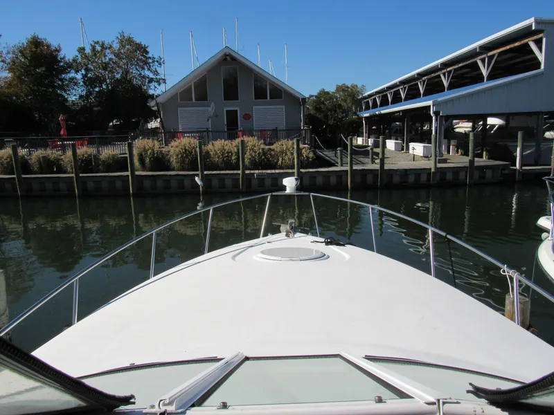 Slide: The Image of 2003 Cruisers Yachts 2870 Express docked at marina with boathouse view. - 24