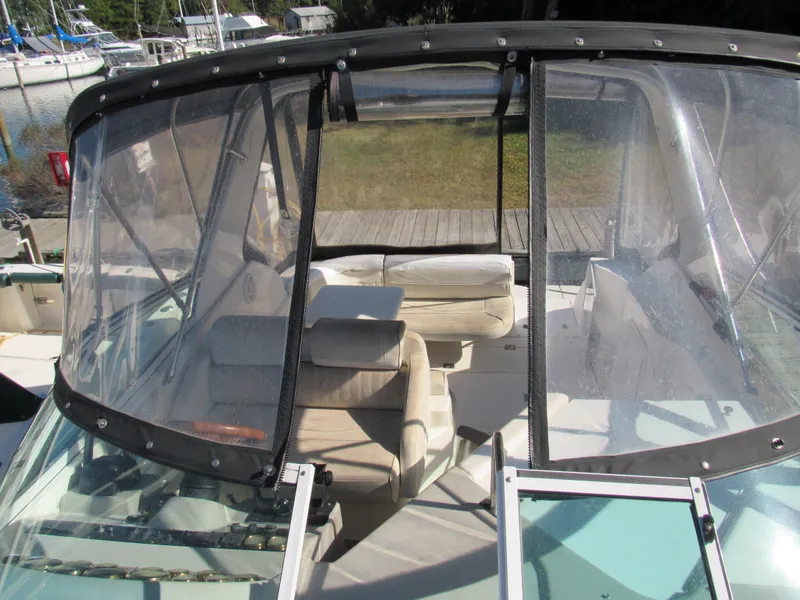 Slide: The Image of 2003 Cruisers Yachts 2870 Express boat interior with clear canopy, docked near sailboats. - 29
