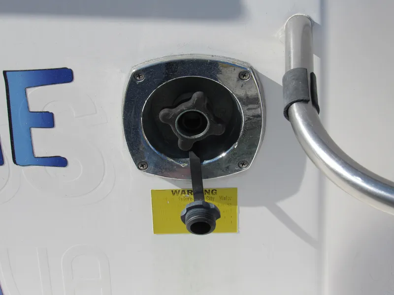 Slide: The Image of 2003 Cruisers Yachts 2870 Express water inlet with warning label and chrome finish. - 32