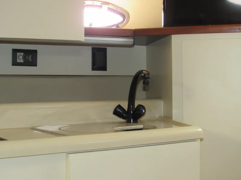 Slide: The Image of 2003 Cruisers Yachts 2870 Express kitchen sink with modern faucet and cabinetry. - 37