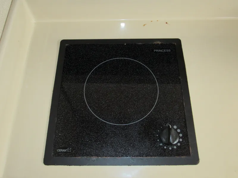 Slide: The Image of Ceramic cooktop on 2003 Cruisers Yachts 2870 Express, featuring a single burner and control knob. - 39