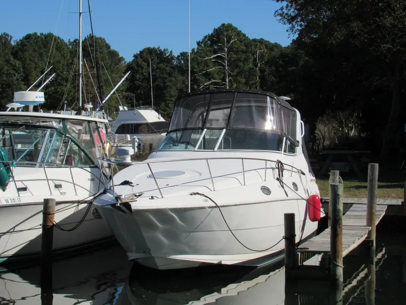 Slide: The Image of 2003 Cruisers Yachts 2870 Express docked at marina, surrounded by trees. - 4