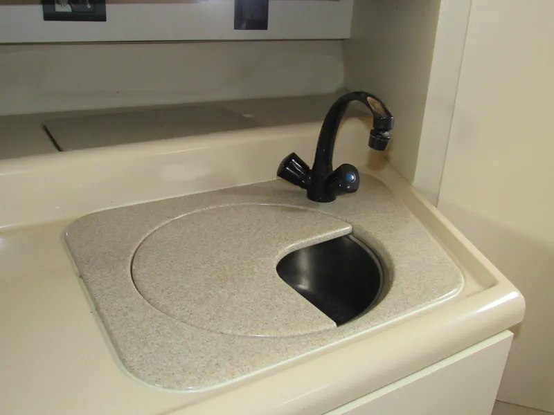 Slide: The Image of 2003 Cruisers Yachts 2870 Express sink with beige countertop and black faucet. - 40