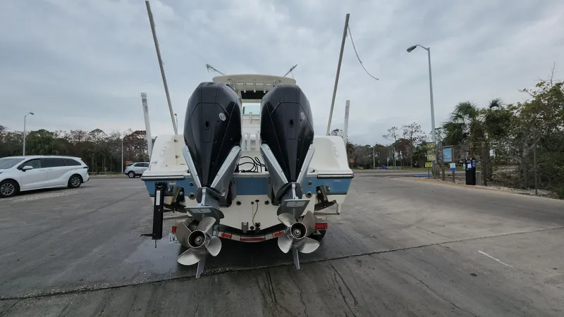 Slide: The Image of 2019 Mako 284 CC boat with dual outboard engines in a parking lot. - 11