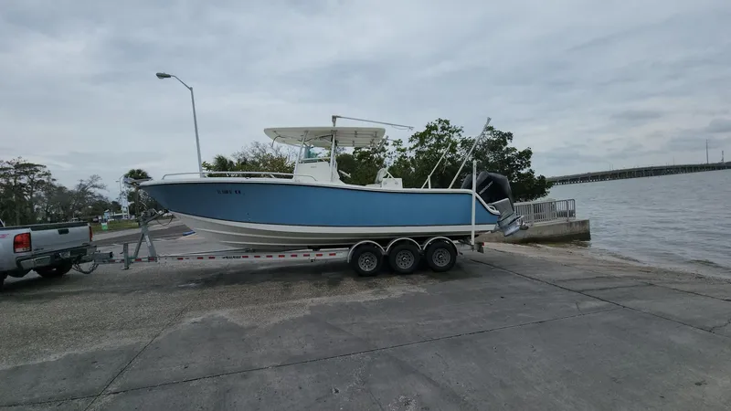Slide: The Image of 2019 Mako 284 CC boat on trailer near water, ready for launch. - 14