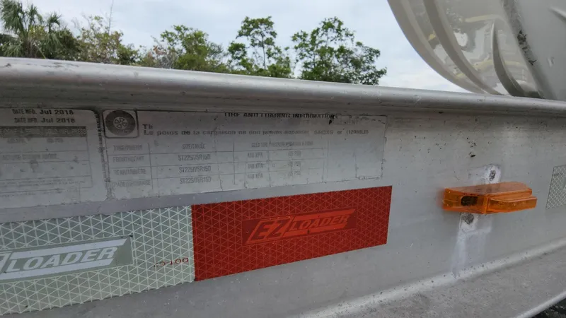 Slide: The Image of Close-up of a 2019 Mako 284 CC boat trailer with labels and reflectors. - 29
