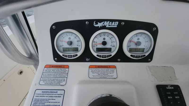 Slide: The Image of Dashboard of 2019 Mako 284 CC boat with gauges and warning labels. - 32