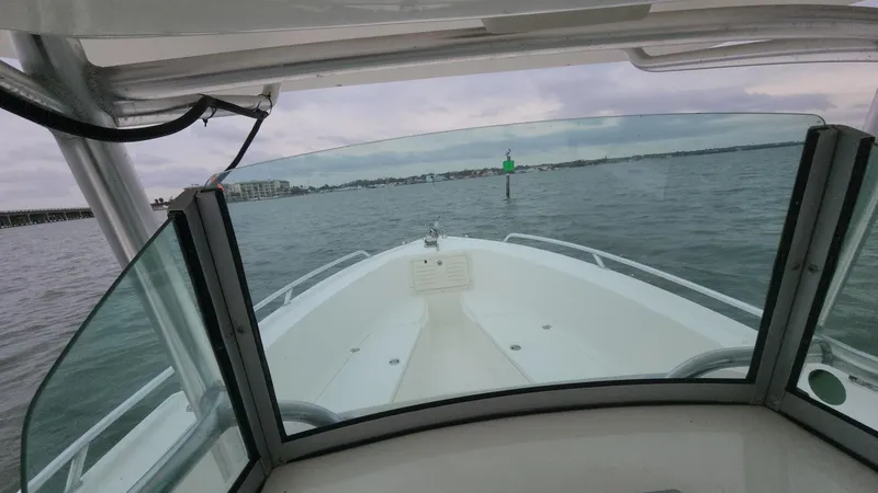 Slide: The Image of 2019 Mako 284 CC boat navigating calm waters, view from the helm. - 33