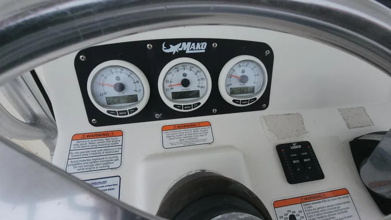 Slide: The Image of Dashboard of 2019 Mako 284 CC boat with gauges and warning labels. - 34