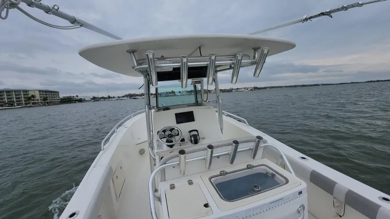 Slide: The Image of 2019 Mako 284 CC boat on water, featuring center console and rod holders. - 36