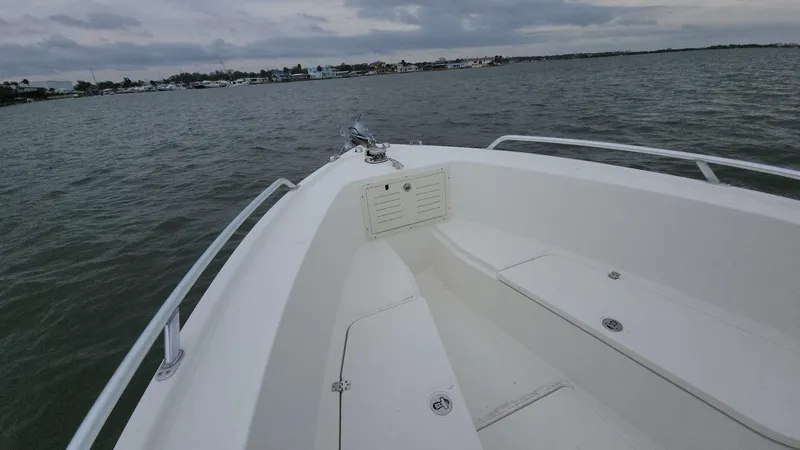 Slide: The Image of 2019 Mako 284 CC boat on calm waters under cloudy skies. - 38