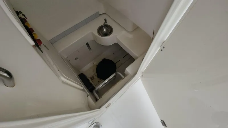 Slide: The Image of Interior of 2019 Mako 284 CC boat, featuring a compact sink and storage area. - 42