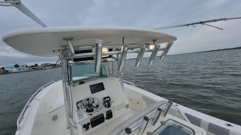 Slide: The Image of 2019 Mako 284 CC boat on water, featuring a modern helm and rod holders. - 46