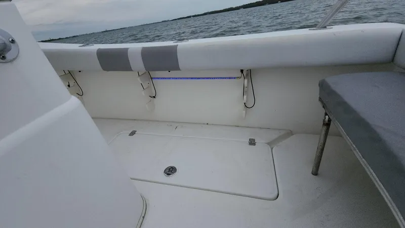 Slide: The Image of 2019 Mako 284 CC boat interior with seating and storage, near water. - 47