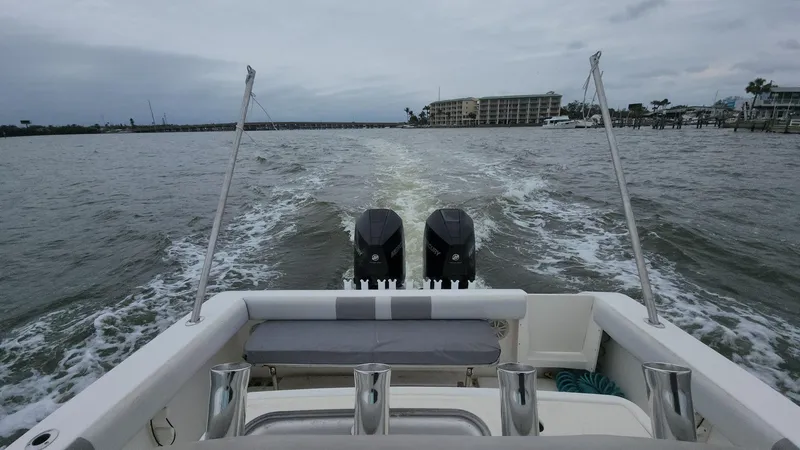 Slide: The Image of 2019 Mako 284 CC boat cruising on open water with twin engines. - 49