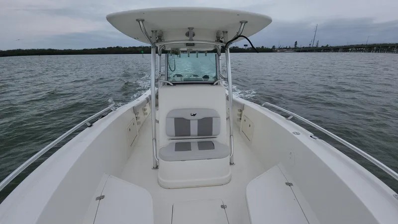 Slide: The Image of 2019 Mako 284 CC boat on calm water, featuring spacious seating and sleek design. - 5