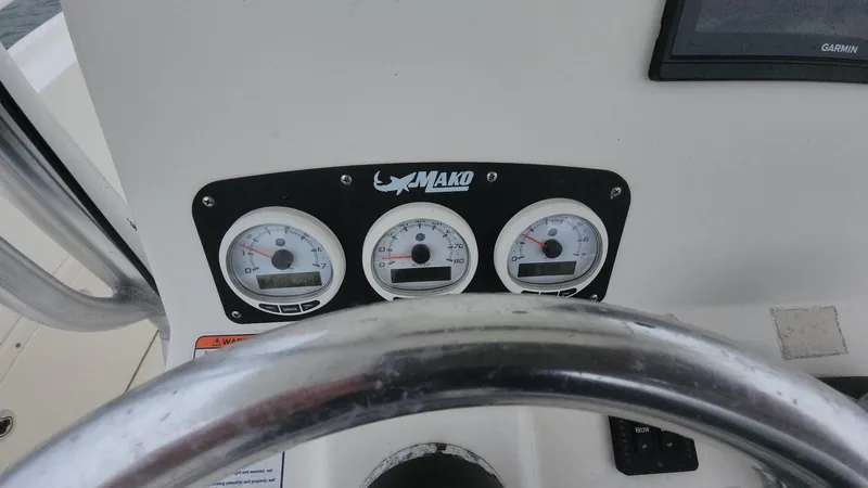 Slide: The Image of Dashboard of 2019 Mako 284 CC boat with gauges and steering wheel. - 50