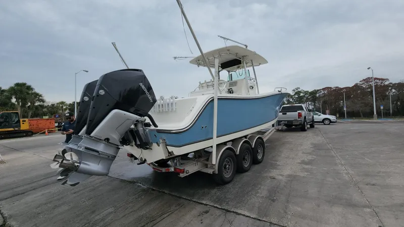 Slide: The Image of 2019 Mako 284 CC boat on trailer with outboard motor, parked in a lot. - 8