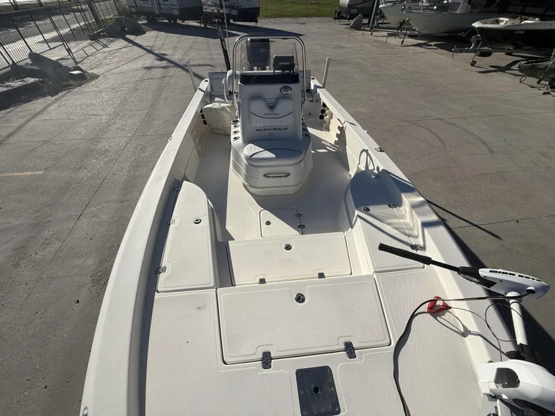 Slide: The Image of 2013 NauticStar 2200 T boat, spacious deck, parked outdoors. - 10