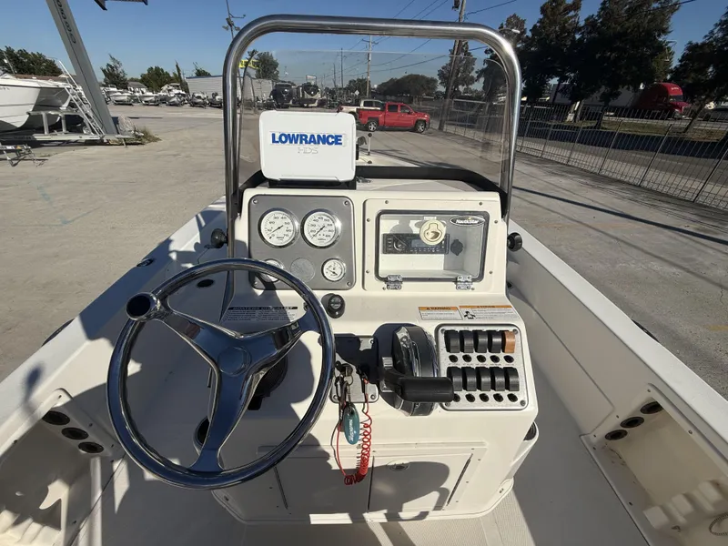 Slide: The Image of 2013 NauticStar 2200 T boat dashboard with steering wheel and controls. - 11