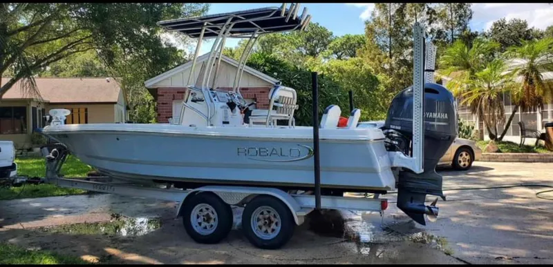 Slide: The Image of 2019 Robalo 206 Cayman boat on trailer with Yamaha outboard motor in residential driveway. - 0