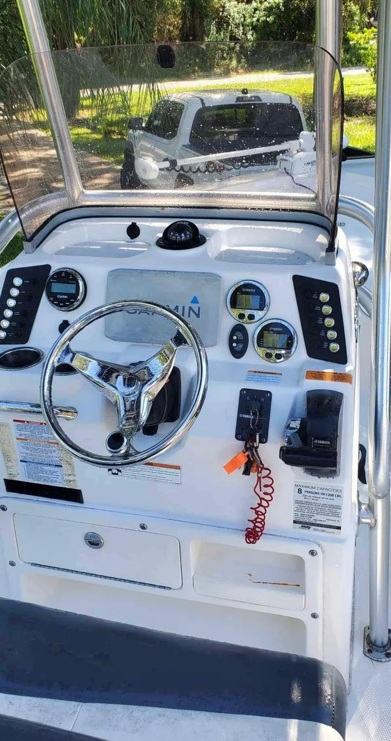 Slide: The Image of 2019 Robalo 206 Cayman boat dashboard with steering wheel and control panel. - 2