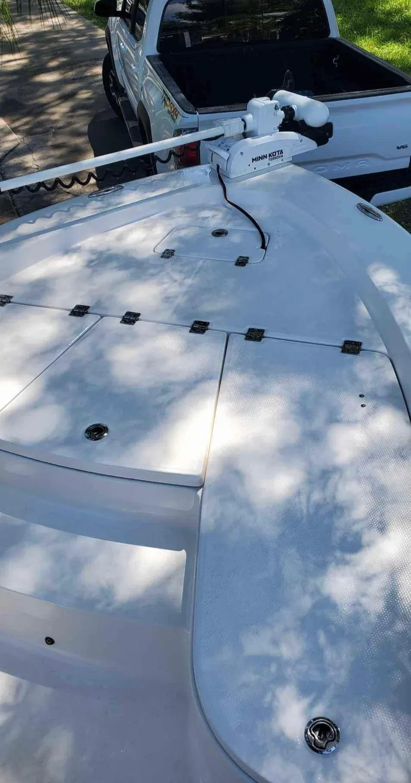 Slide: The Image of 2019 Robalo 206 Cayman boat deck with trolling motor, parked near a truck. - 8