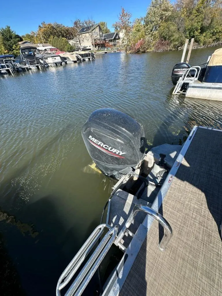 Slide: The Image of 2020 Harris Cruiser 210 SL with Mercury outboard motor docked on a sunny day. - 11