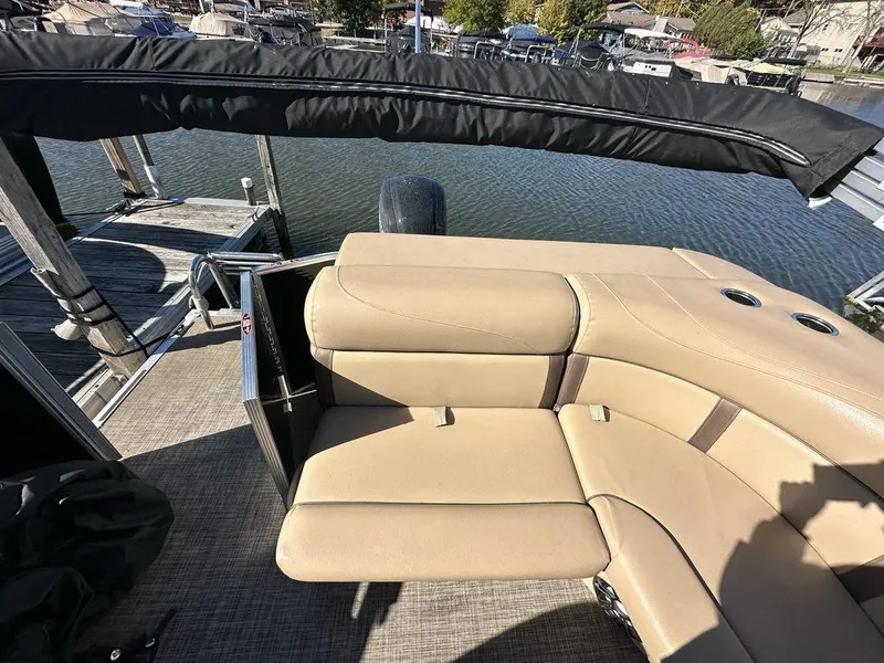 Slide: The Image of 2020 Harris Cruiser 210 SL boat with beige seating, docked by the water. - 12