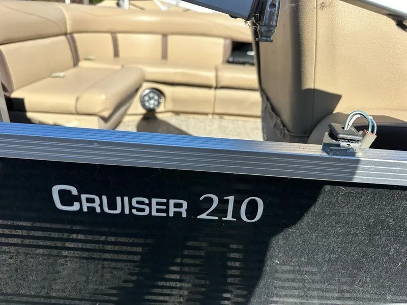 Slide: The Image of 2020 Harris Cruiser 210 SL boat interior with beige seating and visible branding. - 3