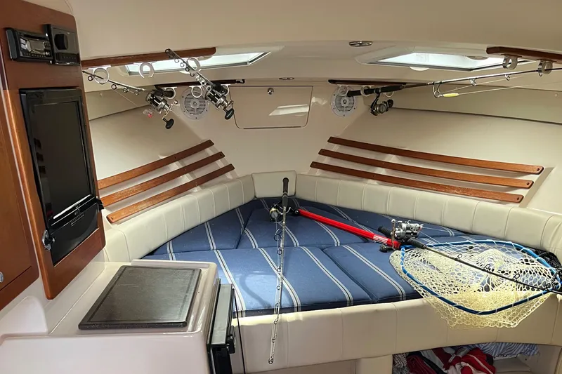 Slide: The Image of 2009 Grady-White Express 330 cabin interior with fishing gear and cozy seating. - 11