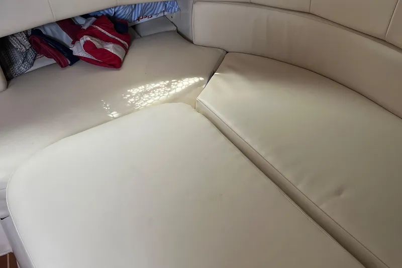 Slide: The Image of 2009 Grady-White Express 330 cabin interior with beige seating and storage area. - 13