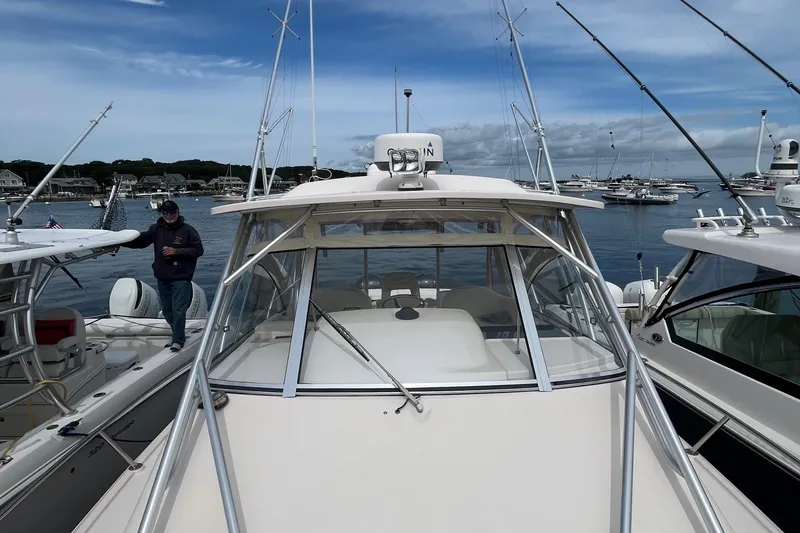 Slide: The Image of 2009 Grady-White Express 330 boat docked in a marina, surrounded by other vessels. - 17
