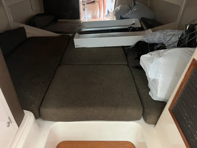 Slide: The Image of 2009 Grady-White Express 330 cabin interior with cushioned seating and storage. - 2