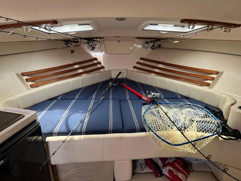 Slide: The Image of 2009 Grady-White Express 330 cabin with fishing gear and striped bedding. - 3