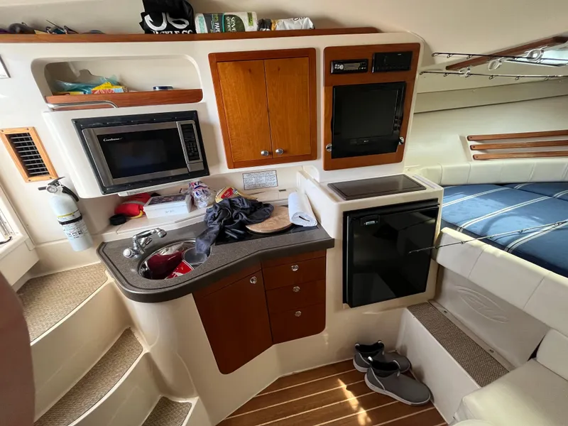 Slide: The Image of 2009 Grady-White Express 330 cabin interior with kitchenette, microwave, and seating area. - 4