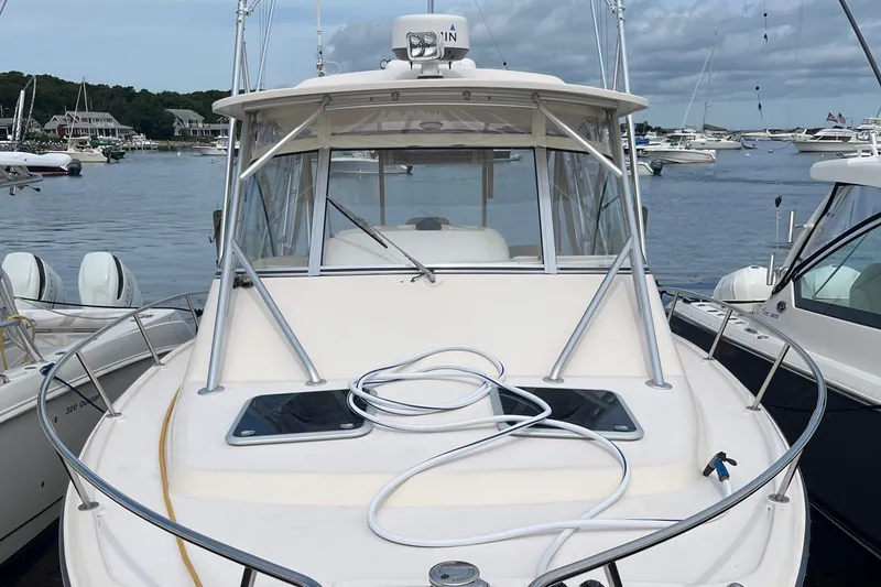 Slide: The Image of 2009 Grady-White Express 330 boat docked in a marina, surrounded by other vessels. - 7