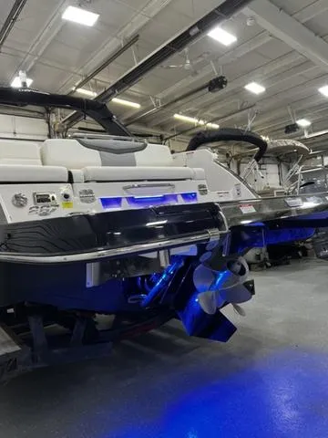 Slide: The Image of 2024 Chaparral 287 SSX boat in showroom with illuminated blue lighting. - 11