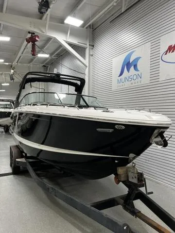 Slide: The Image of 2024 Chaparral 287 SSX boat in showroom, black hull, on trailer. - 5