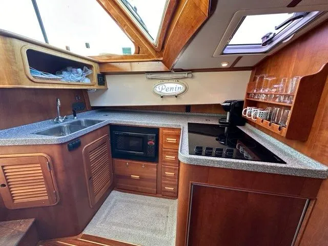 Slide: The Image of Interior of 2003 Hinckley Talaria 44 FB yacht kitchen with wood cabinetry and modern appliances. - 14