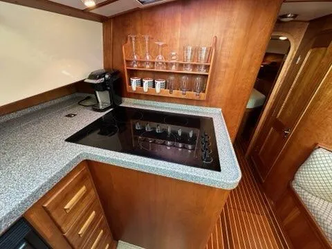 Slide: The Image of Luxurious 2003 Hinckley Talaria 44 FB yacht kitchen with modern appliances and wooden cabinetry. - 15